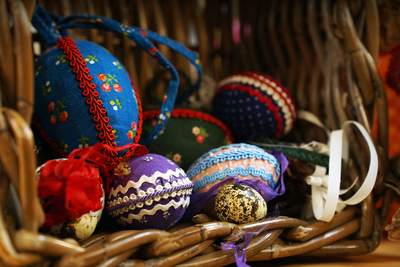 Auf dem Bild sind bunte, dekorierte Ostereier in einem Korb zu sehen.