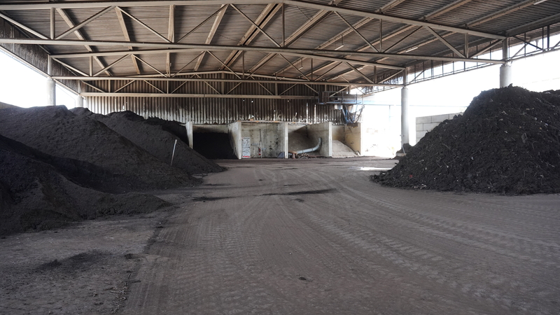 Lagerhalle mit Stahlträgerdach; große Kompost- bzw. Erdhaufen; Betonboden